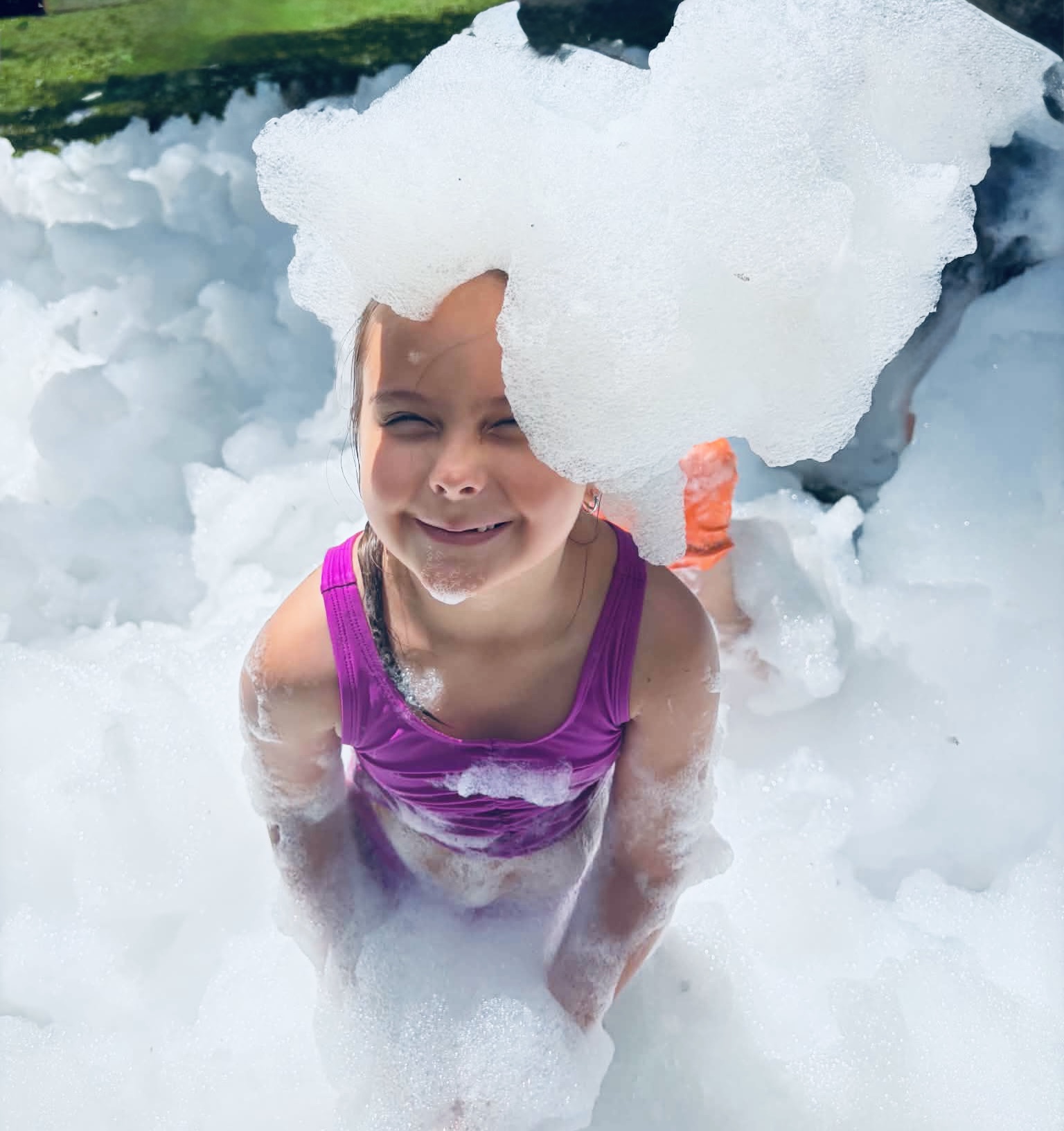 A grinning girl covered in foam at a foam party
