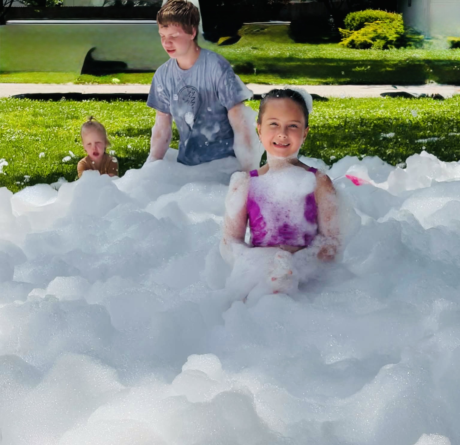Three kids buried up to their shoulders in foam