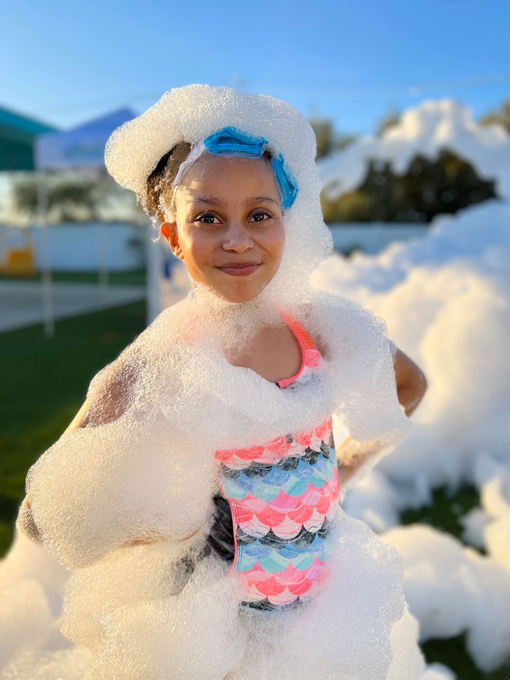 A girl wearing a tall crown and cape of foam