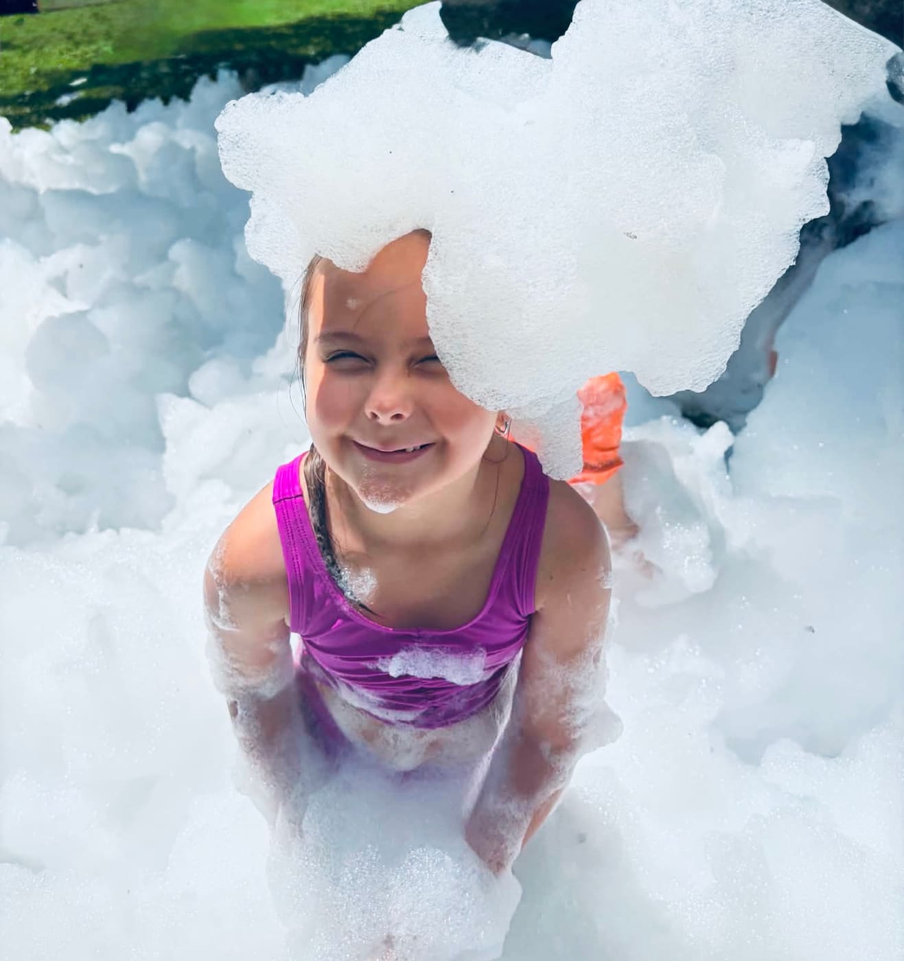 A smiling girl with a pile of foam on her head