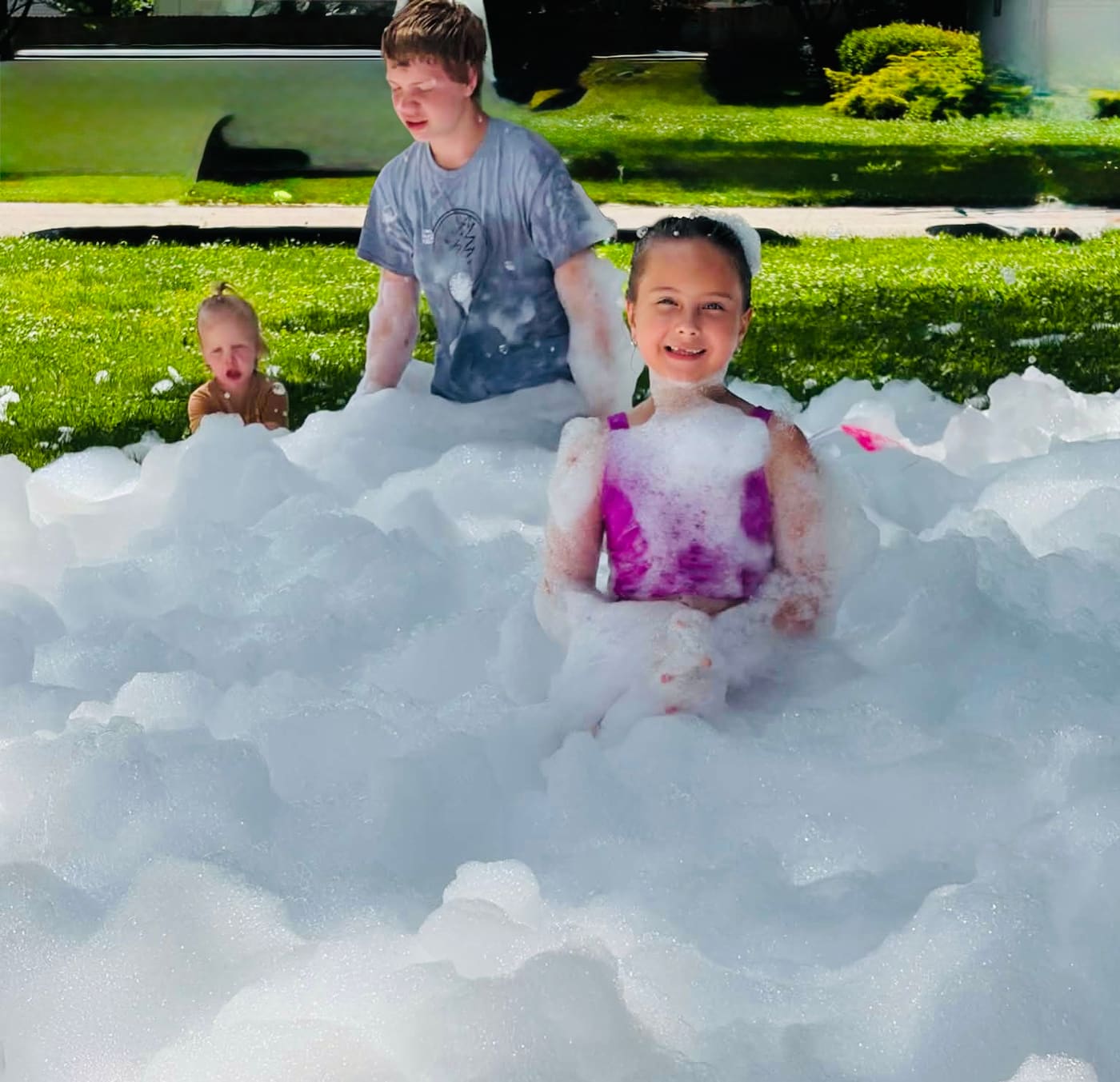 Three kids buried up to their shoulders in foam