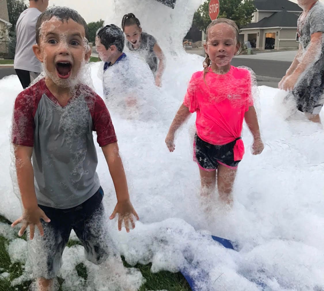 Kids shouting with joy at a neighborhood foam party